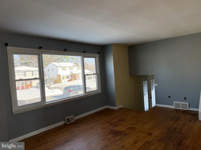 a big room with wooden floor and windows
