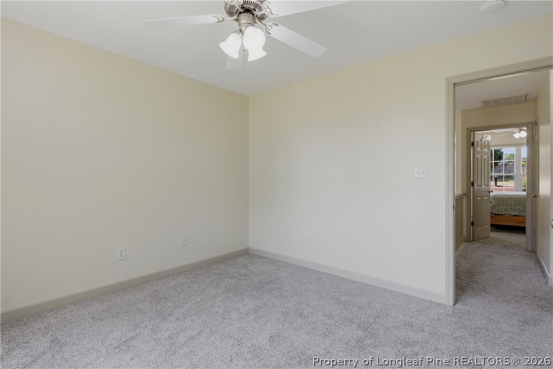 1075 Buffalo Lake Road Sanford, NC 27332 - Photo 35 of 49 an empty room with a chandelier fan and windows