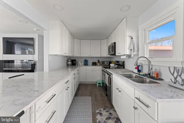 a kitchen with granite countertop a sink stove top oven and cabinets