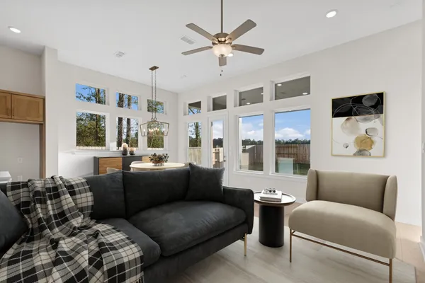 a living room with furniture ceiling fan and a window