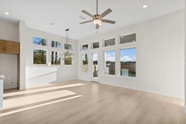 a view of an empty room with a window and a ceiling fan