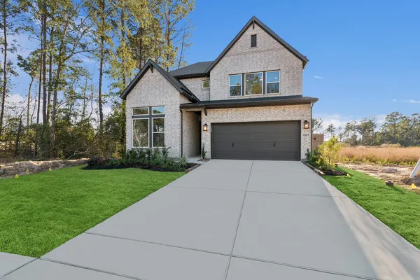 a front view of a house with yard and garage