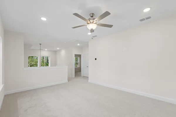 an empty room with window and ceiling fan