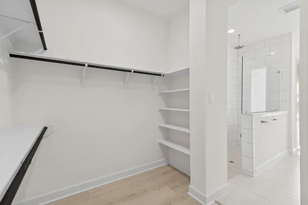 a view of walk in closet with empty racks