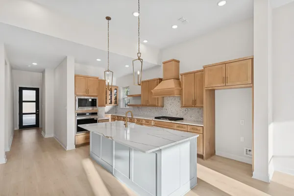 a kitchen with stainless steel appliances granite countertop a sink a stove and a refrigerator