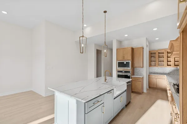 a large kitchen with a table and stainless steel appliances