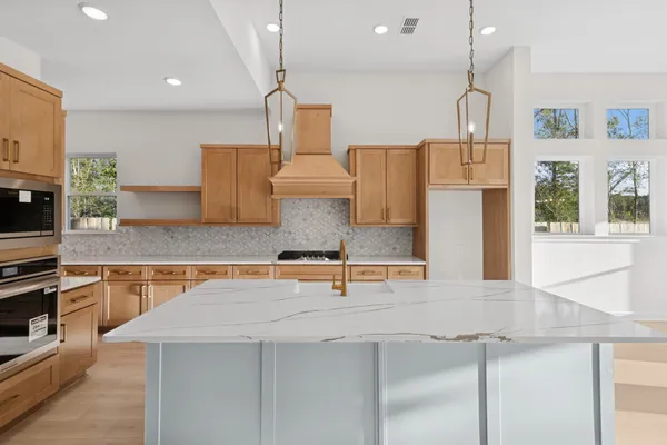 a kitchen with stainless steel appliances granite countertop a sink a stove and a refrigerator