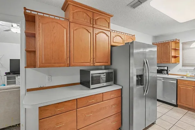 a kitchen with stainless steel appliances granite countertop a refrigerator and a stove top oven
