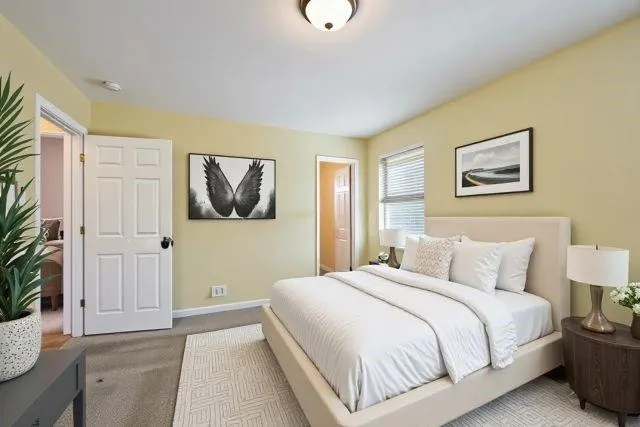 a bedroom with a bed and a painting on the wall