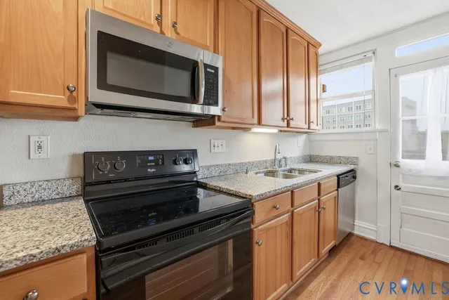a kitchen with stainless steel appliances granite countertop a stove microwave and sink