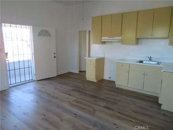 a view of a kitchen with wooden floor and a sink