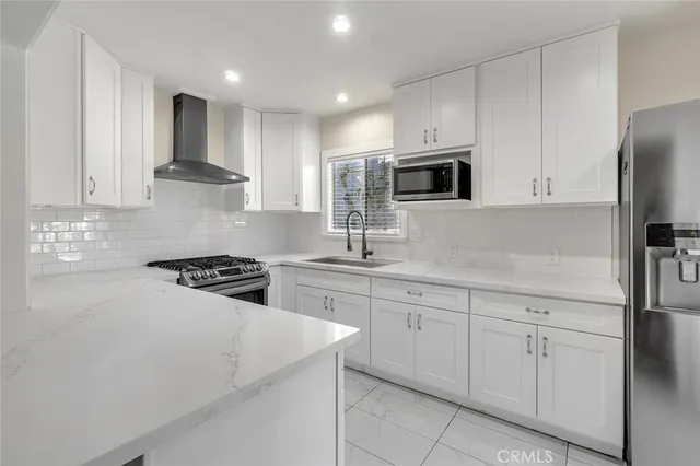 a kitchen with white cabinets and stainless steel appliances