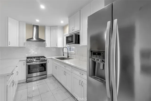 a kitchen with stainless steel appliances granite countertop a refrigerator and a stove
