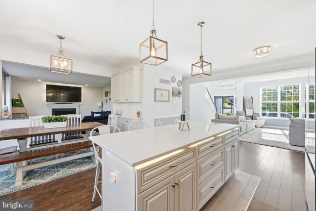 a view of a kitchen with kitchen island granite countertop a sink and a wooden floor