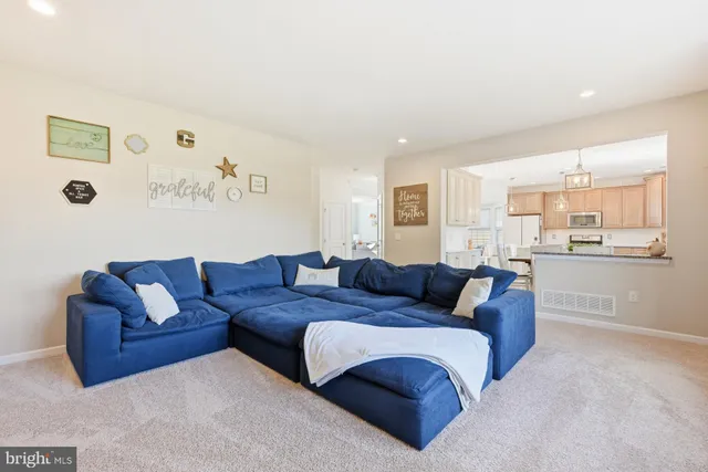 a living room with furniture and view of kitchen