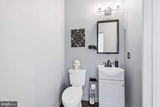 a bathroom with a toilet a sink and mirror