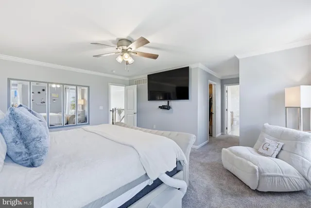 a spacious bedroom with a bed and a flat screen tv