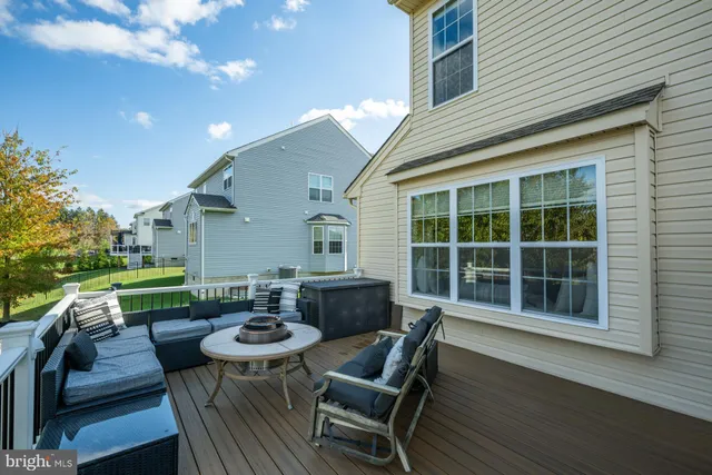 a view of a patio with couches table and chairs with wooden floor and fence