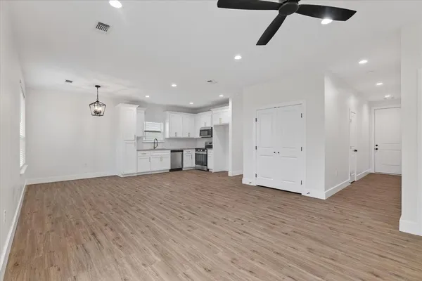 a view of an empty room with wooden floor