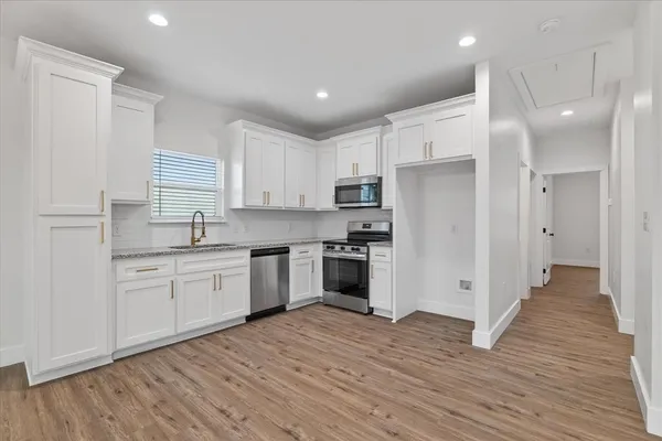 a kitchen with a refrigerator and white cabinets