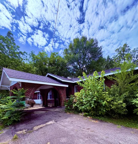 a view of a house with a yard and potted plants