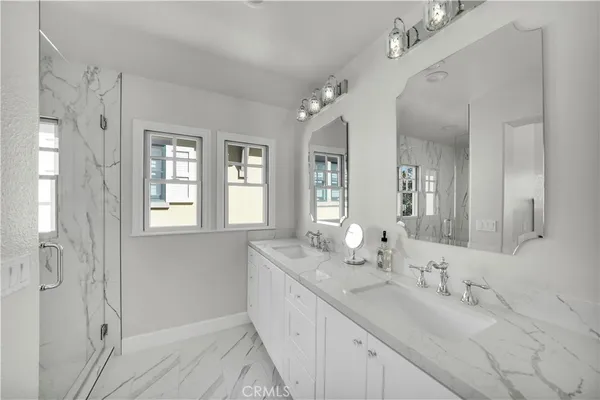a bathroom with double vanity sinks and a mirror