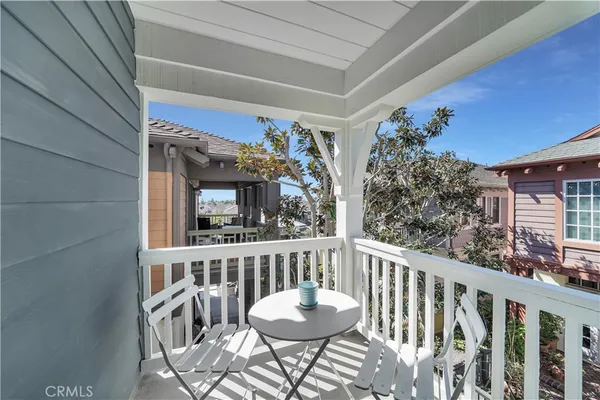 a view of a chair and tables in the balcony