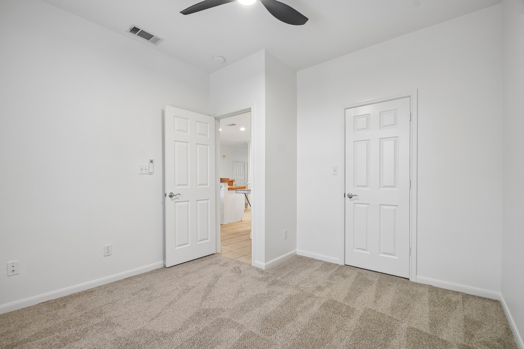 20609 Bridle Path Road Lago Vista, TX 78645 - Photo 17 of 30 A well-lit room with fresh carpeting and a practical ceiling fan, ready for personal touches.