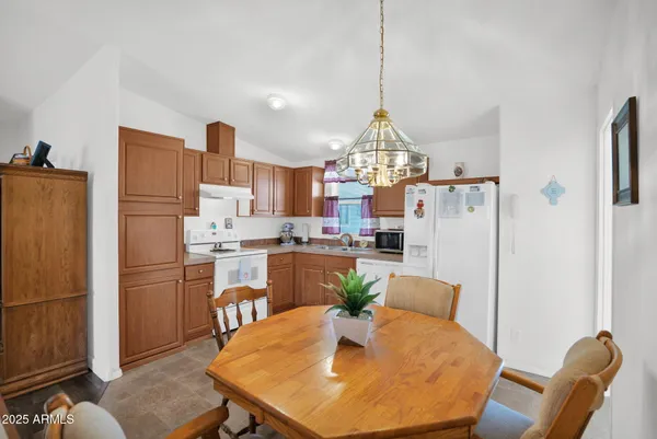 a kitchen with stainless steel appliances granite countertop a refrigerator a sink a stove and white cabinets