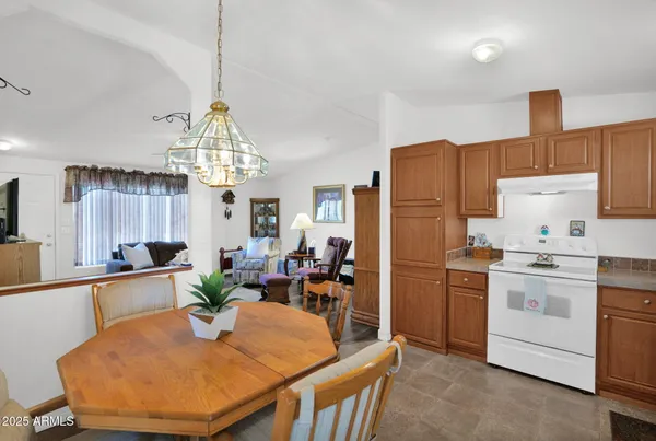 a kitchen with sink a refrigerator and chairs