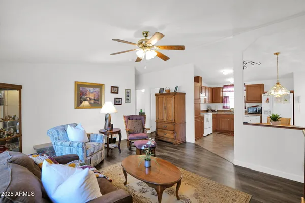 a living room with furniture kitchen view and a chandelier