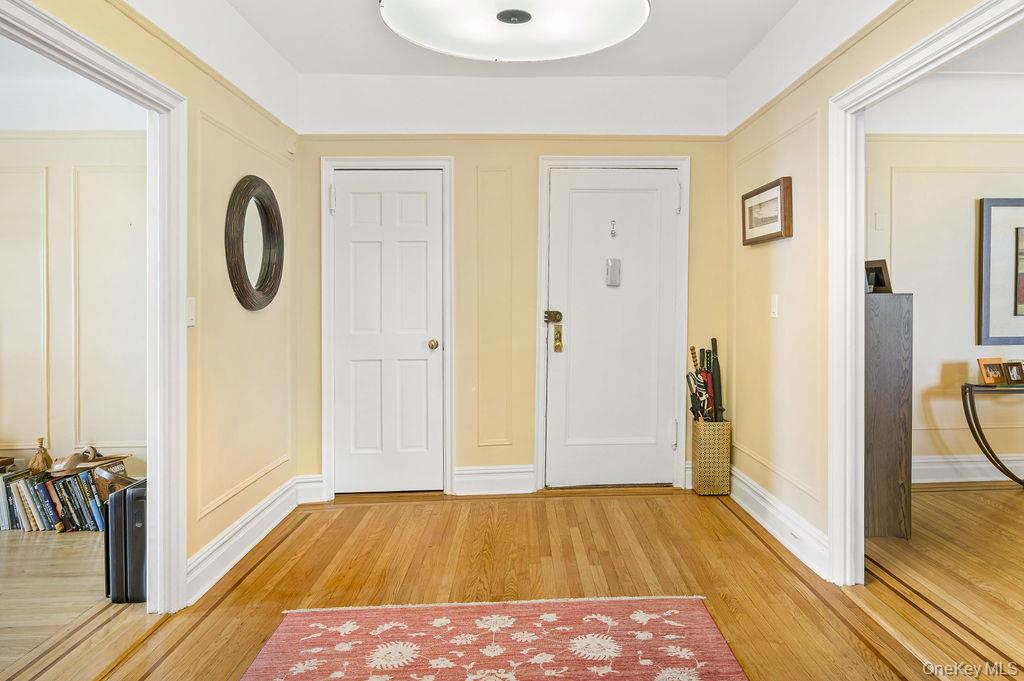 Foyer entrance featuring light wood floors and baseboards