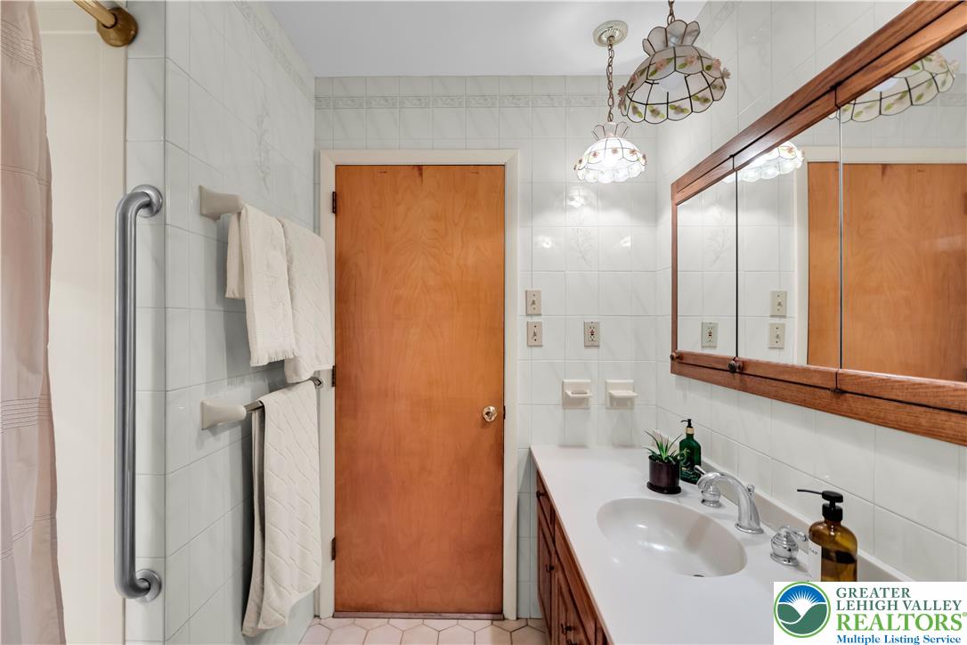 5747 Kernsville Road Orefield, PA 18069 - Photo 33 of 56 a bathroom with a sink a mirror and a shower