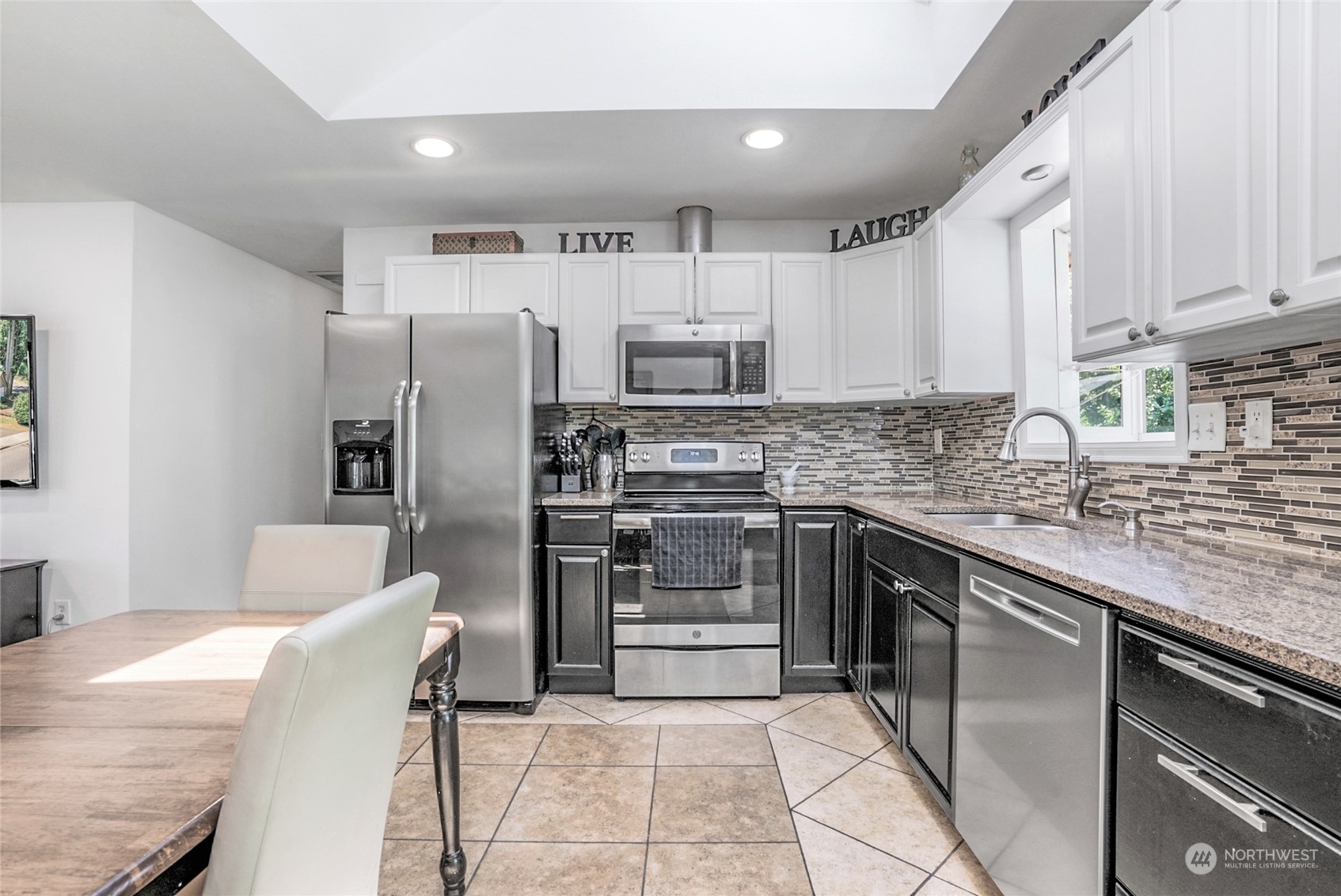 1809 Northeast 27th Street Renton, WA 98056 - Photo 10 of 32 a kitchen with stainless steel appliances granite countertop a refrigerator sink and cabinets