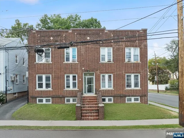 a aerial view of a brick house next to a yard