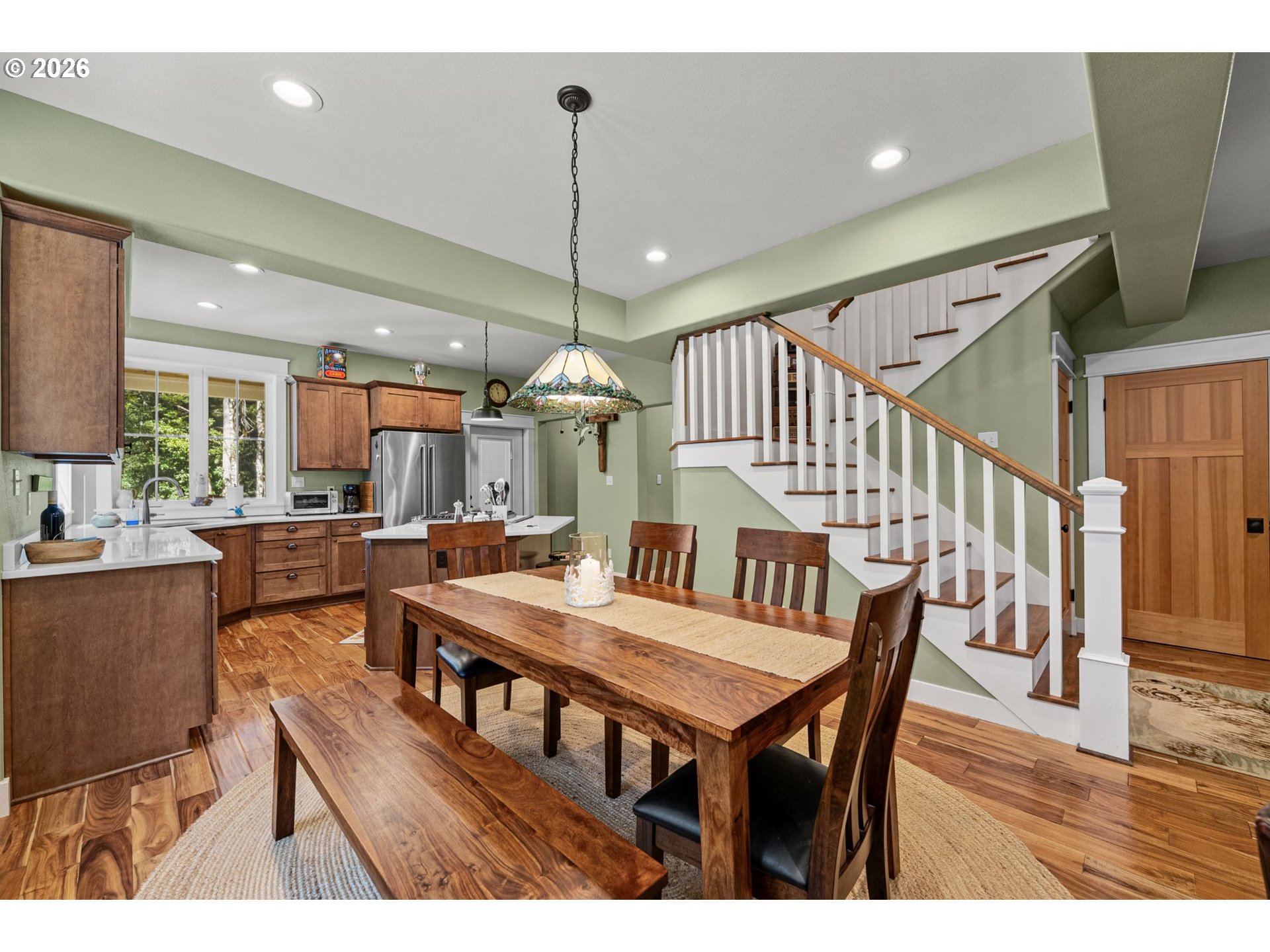 41900 Park Road Port Orford, OR 97465 - Photo 7 of 48 a dining room with wooden floor a chandelier a wooden table and chairs