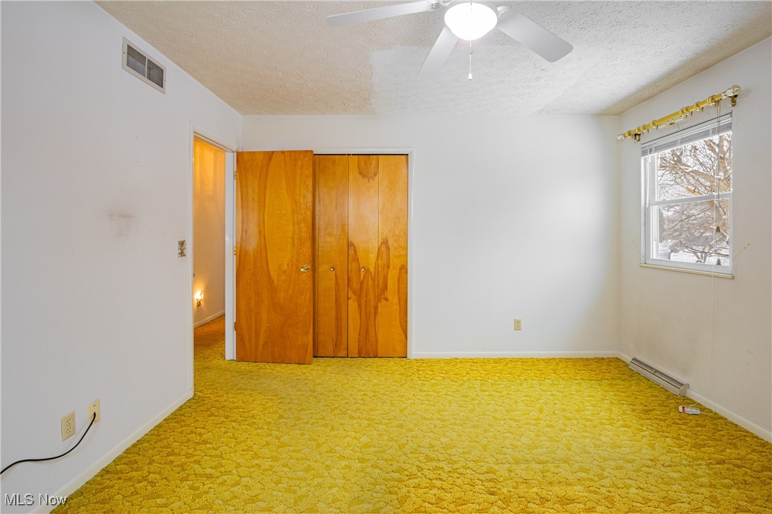 5905 Renninger Road New Franklin, OH 44319 - Photo 16 of 31 Unfurnished bedroom featuring ceiling fan, a closet, carpet, and a textured ceiling