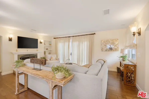 a living room with furniture a flat screen tv and a window