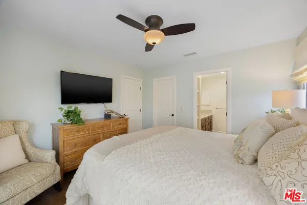 a bedroom with bed tv and window