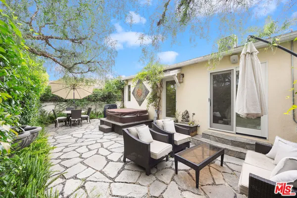 a view of a patio with table and chairs with wooden fence and plants