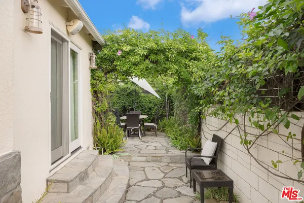 a view of a chair and table in backyard of the house