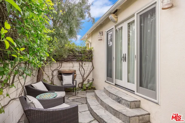 a view of a chair and table in backyard of the house