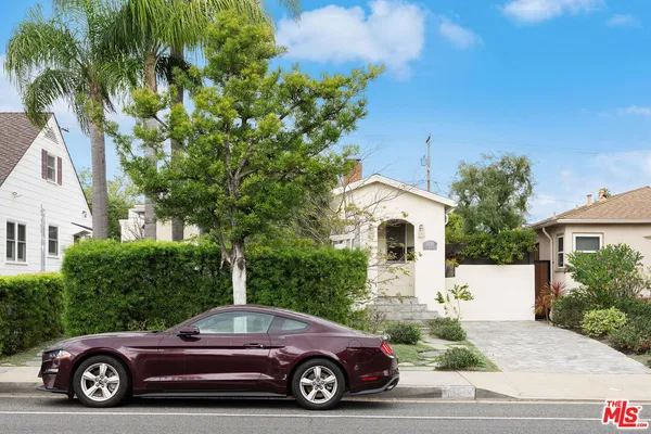 a car parked in front of a white house