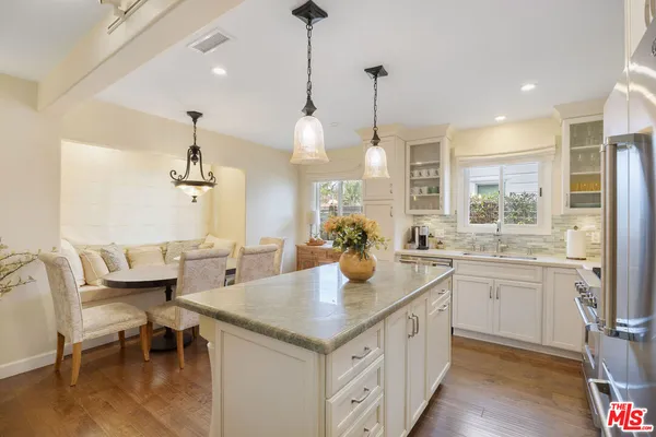 a kitchen with a sink stove and wooden floor