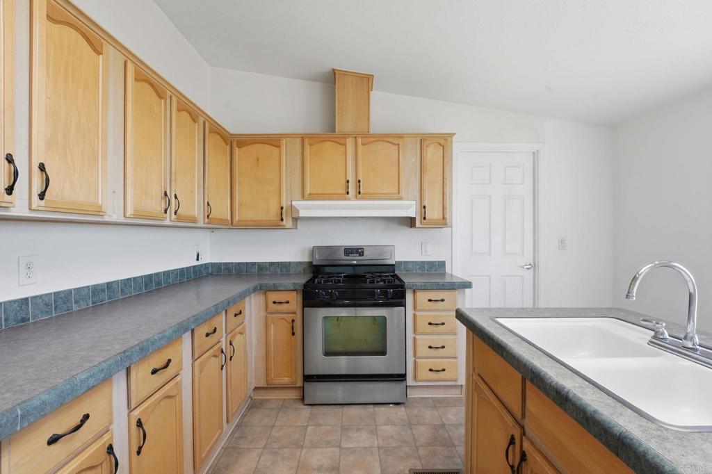 909 Tierra De Luna Road Boulevard, CA 91905 - Photo 11 of 74 a kitchen with stainless steel appliances granite countertop a stove a sink and a microwave