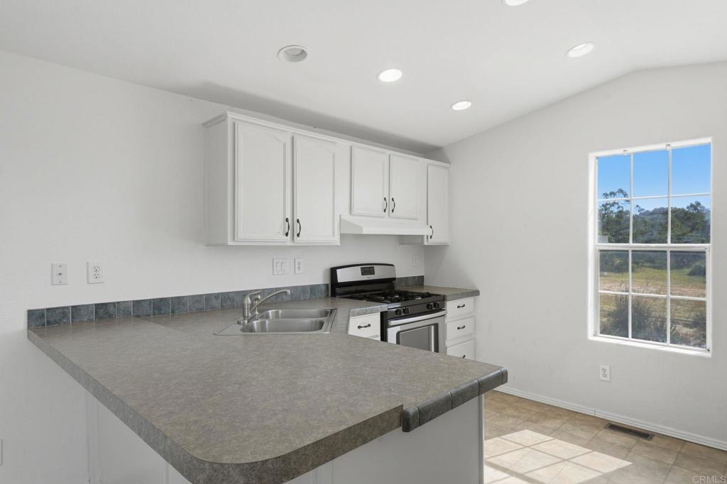 909 Tierra De Luna Road Boulevard, CA 91905 - Photo 14 of 74 a kitchen with granite countertop a stove a sink and a granite counter tops