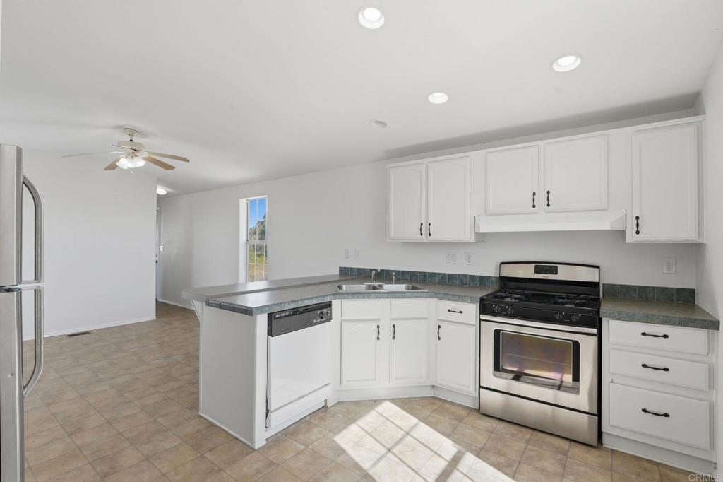 909 Tierra De Luna Road Boulevard, CA 91905 - Photo 16 of 74 a kitchen with granite countertop white cabinets and white appliances