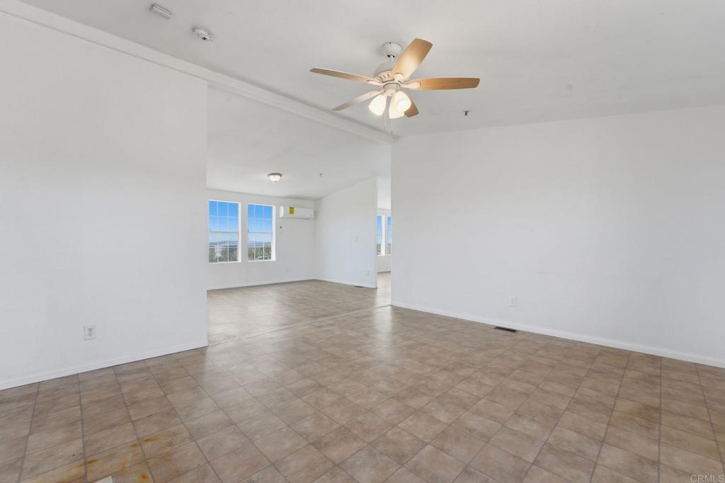 909 Tierra De Luna Road Boulevard, CA 91905 - Photo 27 of 74 an empty room with a chandelier fan and windows