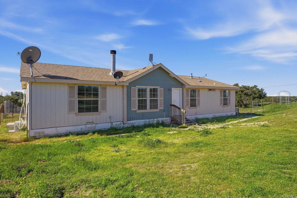 909 Tierra De Luna Road Boulevard, CA 91905 - Photo 3 of 74 a view of a yard in front of a house with a large tree