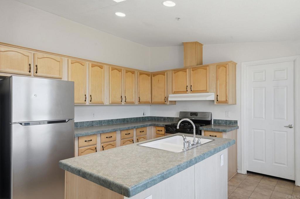 909 Tierra De Luna Road Boulevard, CA 91905 - Photo 8 of 74 a kitchen with a sink a refrigerator and cabinets